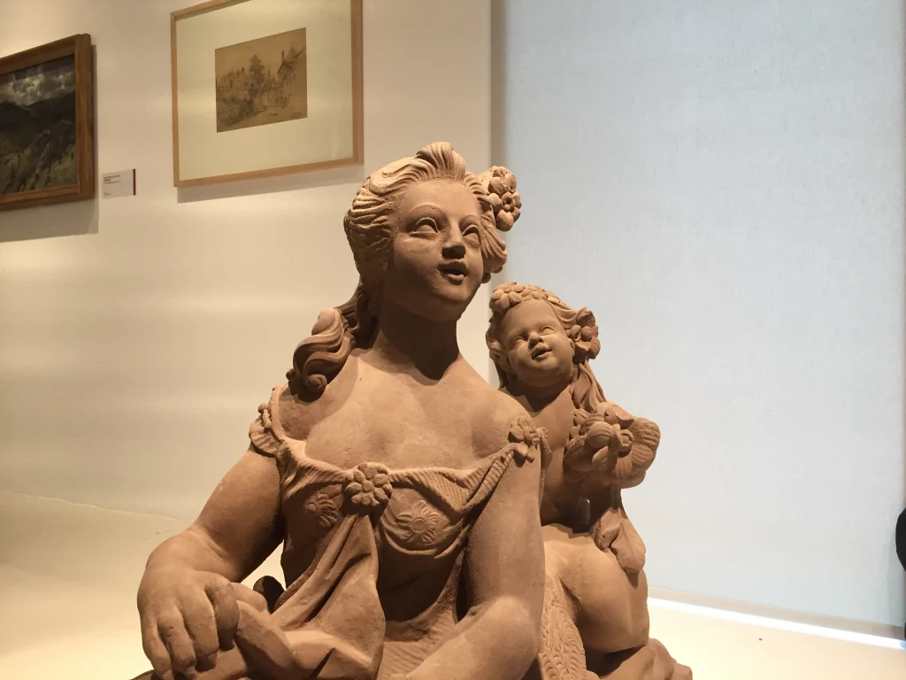 Eine Detailaufnahme einer restaurierten Statue von Frau und Kind bei der Ausstellung.