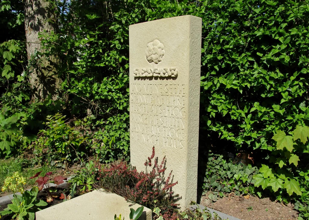 Ein Urnengrabstein mit Blumenmuster und Inschrift.