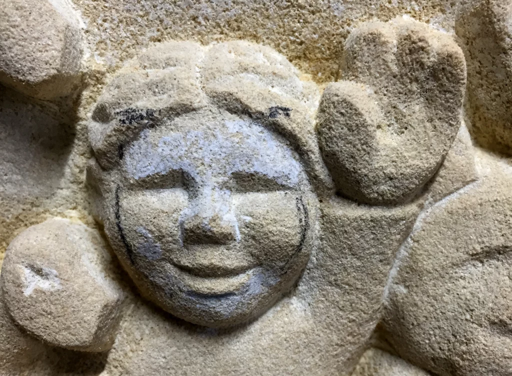 Die Nahaufnahme eines Gesichts auf einem Grabstein.