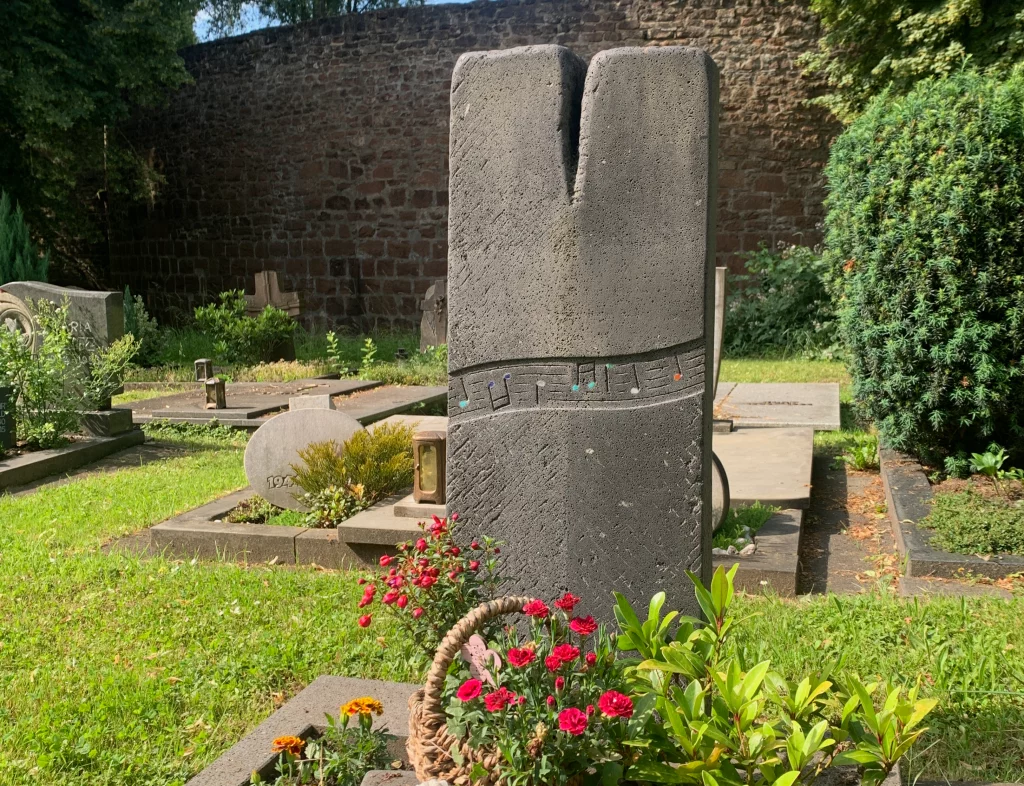 Ein Grabstein mit Musiknoten als Muster, welche in verschiedene Akzentfarben gesetzt sind.