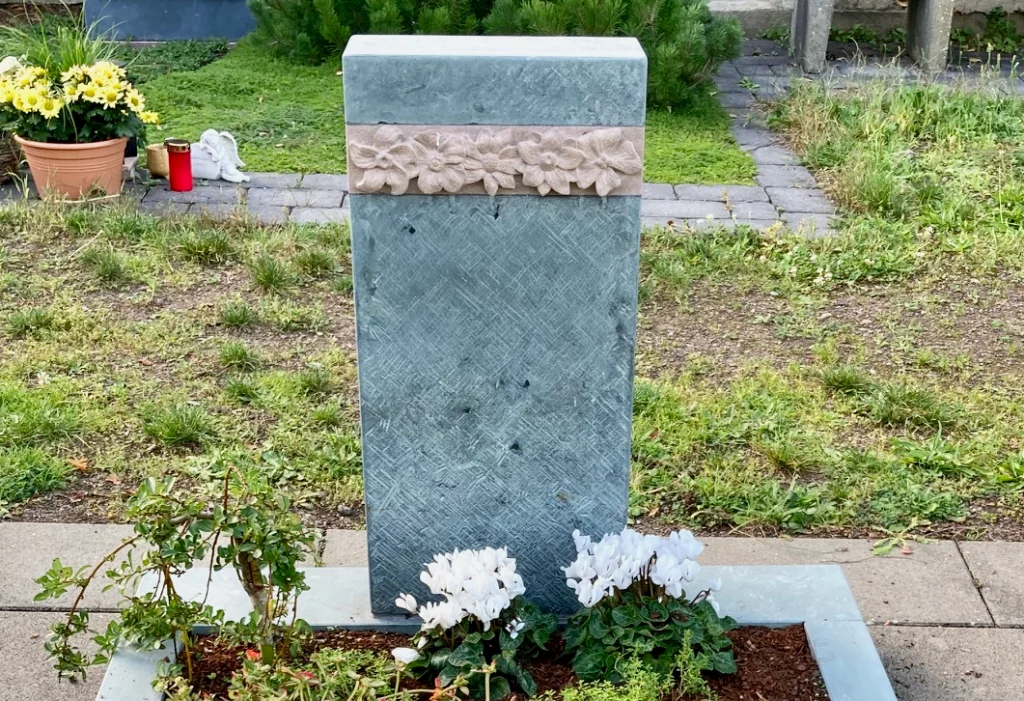 Ein Urnengrabstein mit Blüten Muster.