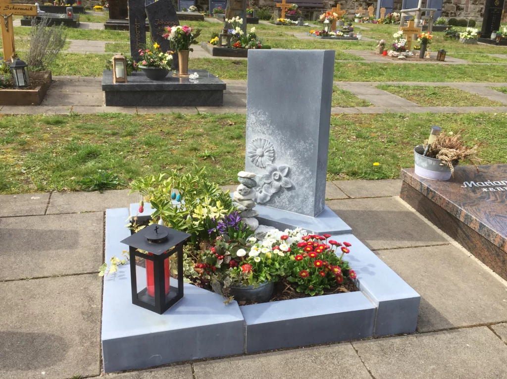 Ein Urnengrabstein mit Blumen Muster.