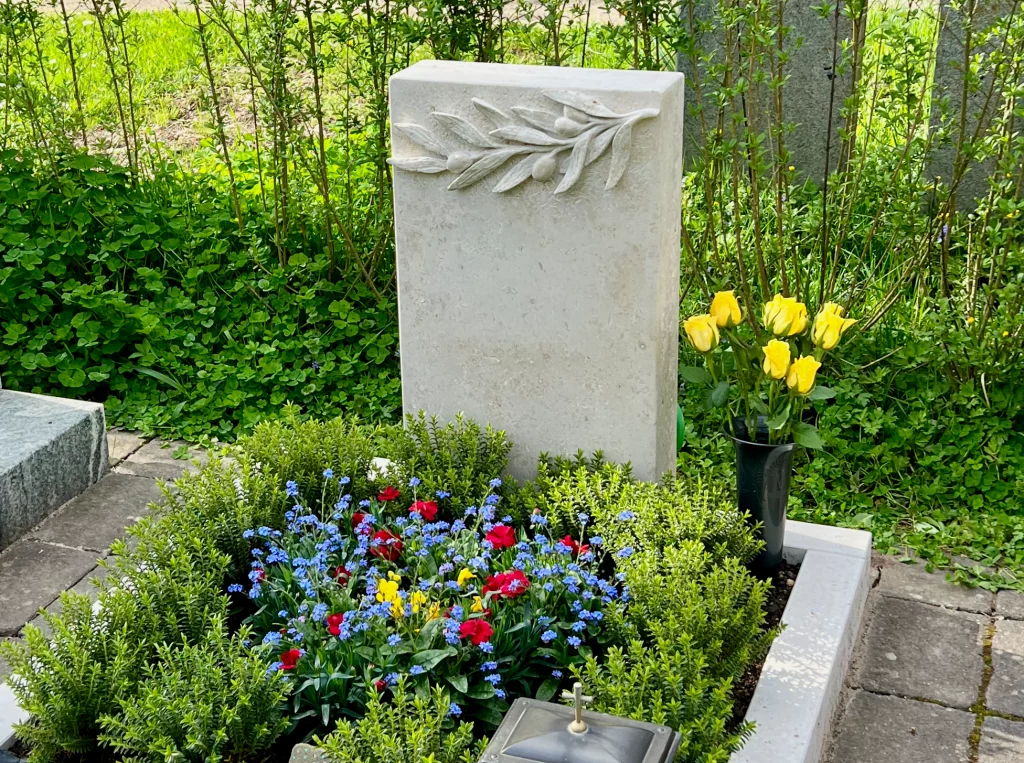 Aufnahme eines Urnengrabsteins mit floralem Olivenzweig Muster.
