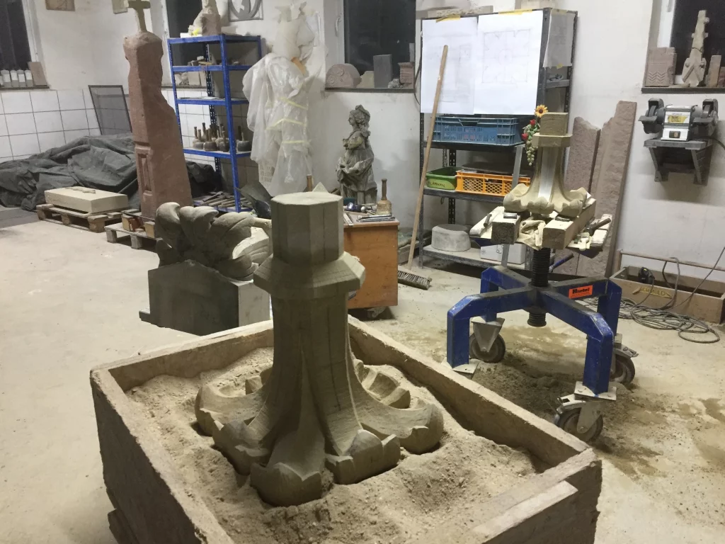 Es wird eine Restauration in der Werkstatt von mehreren Kreuzblumen abgebildet.