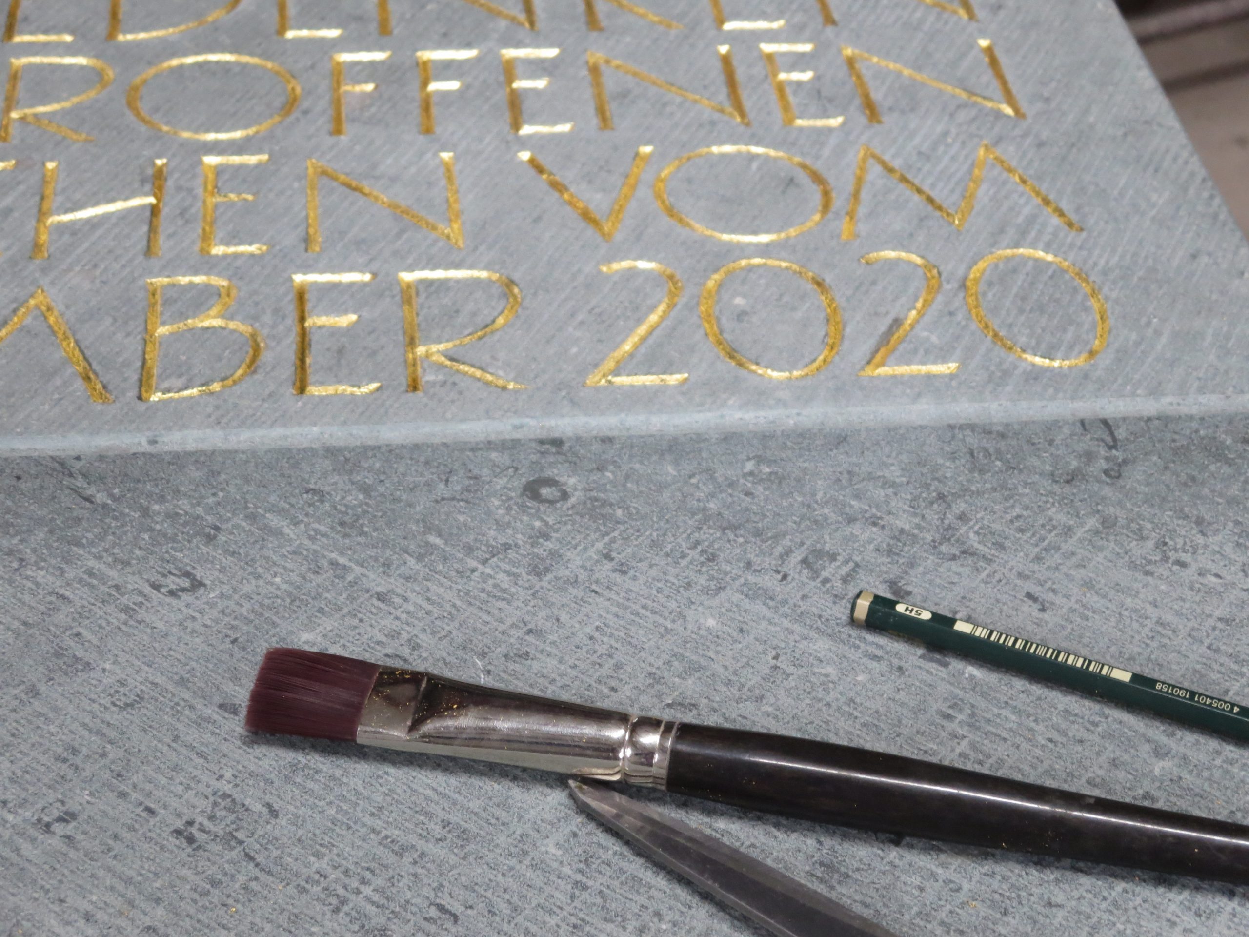 Detailaufnahme der Gedenktafel und ihrer goldenen Schrift.