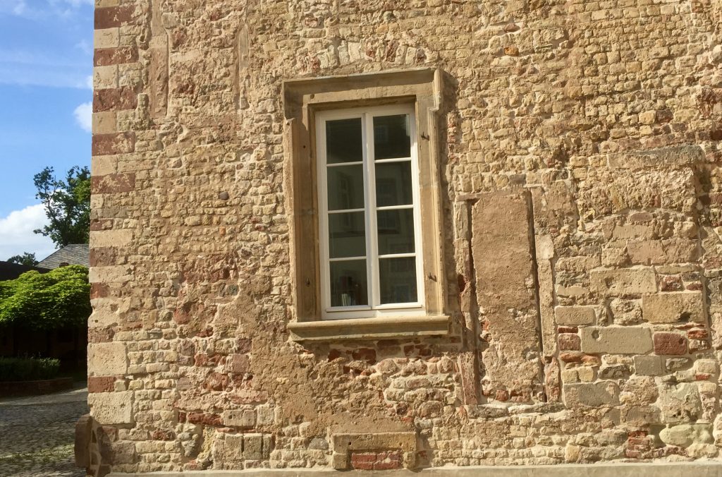 Mauerwerk und ein restauriertes Fenster