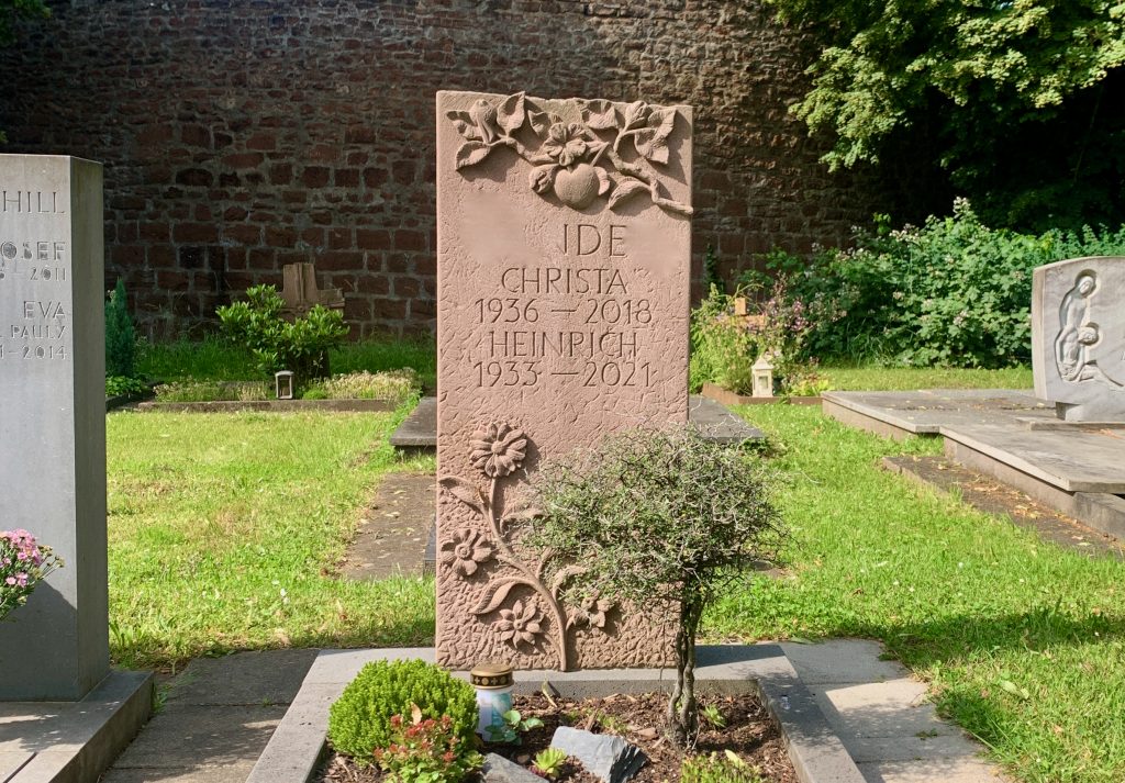 Ein Grabstein mit Apfelbaum- und Blumenmuster.