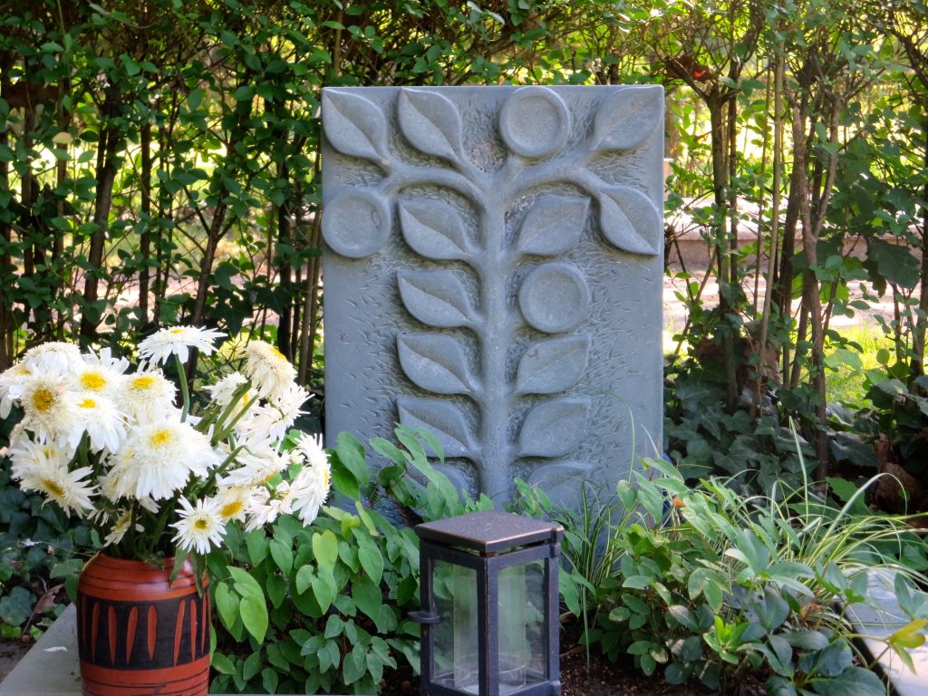 Ein Urnengrabstein mit Rankenmuster darauf.