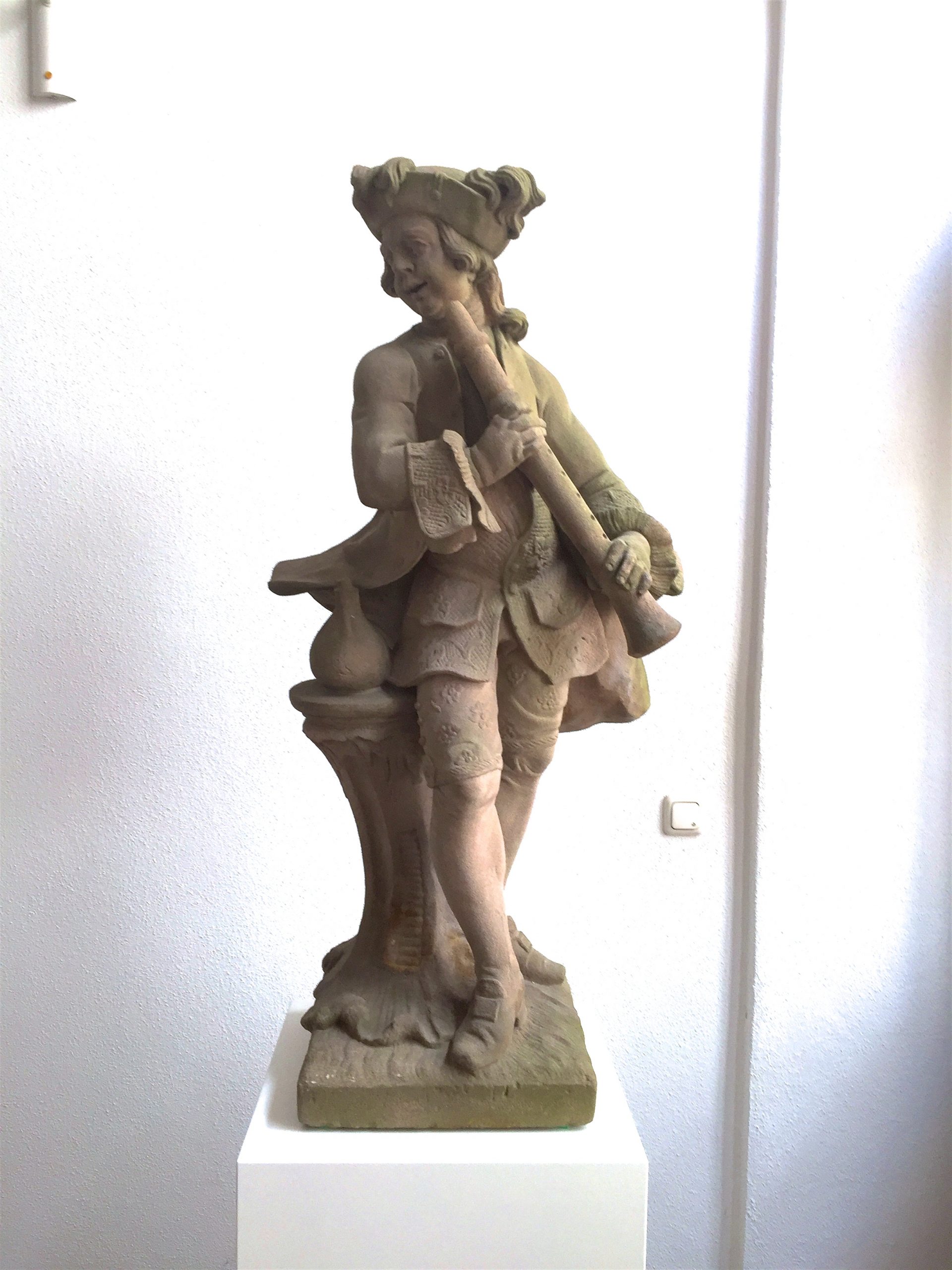 Der restaurierte Flötist der Tietz Musikanten wird auf einer weißen Säule präsentiert.
