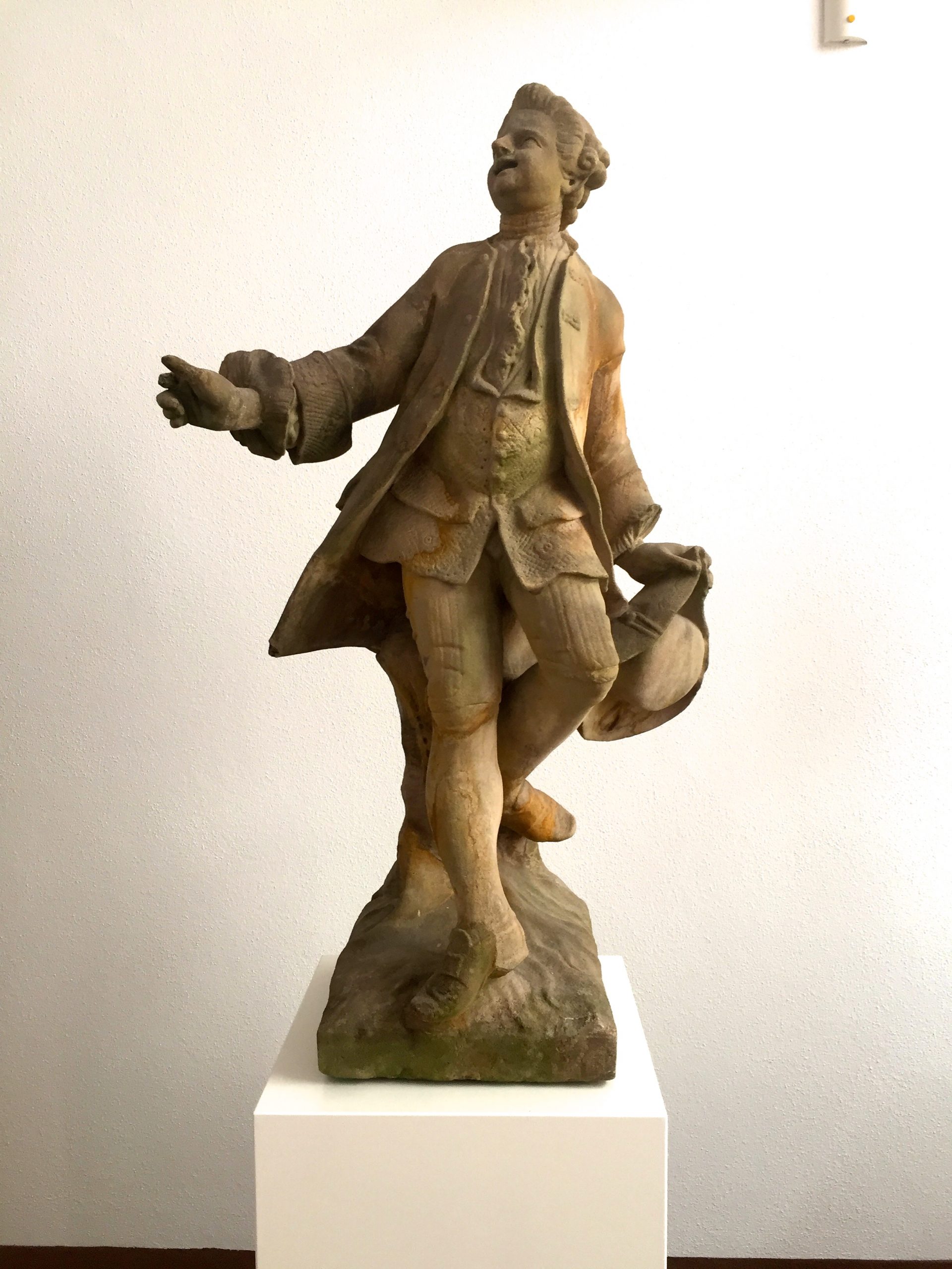 Einer der restaurierten Tietz Musikanten wird auf einer weißen Säule präsentiert.