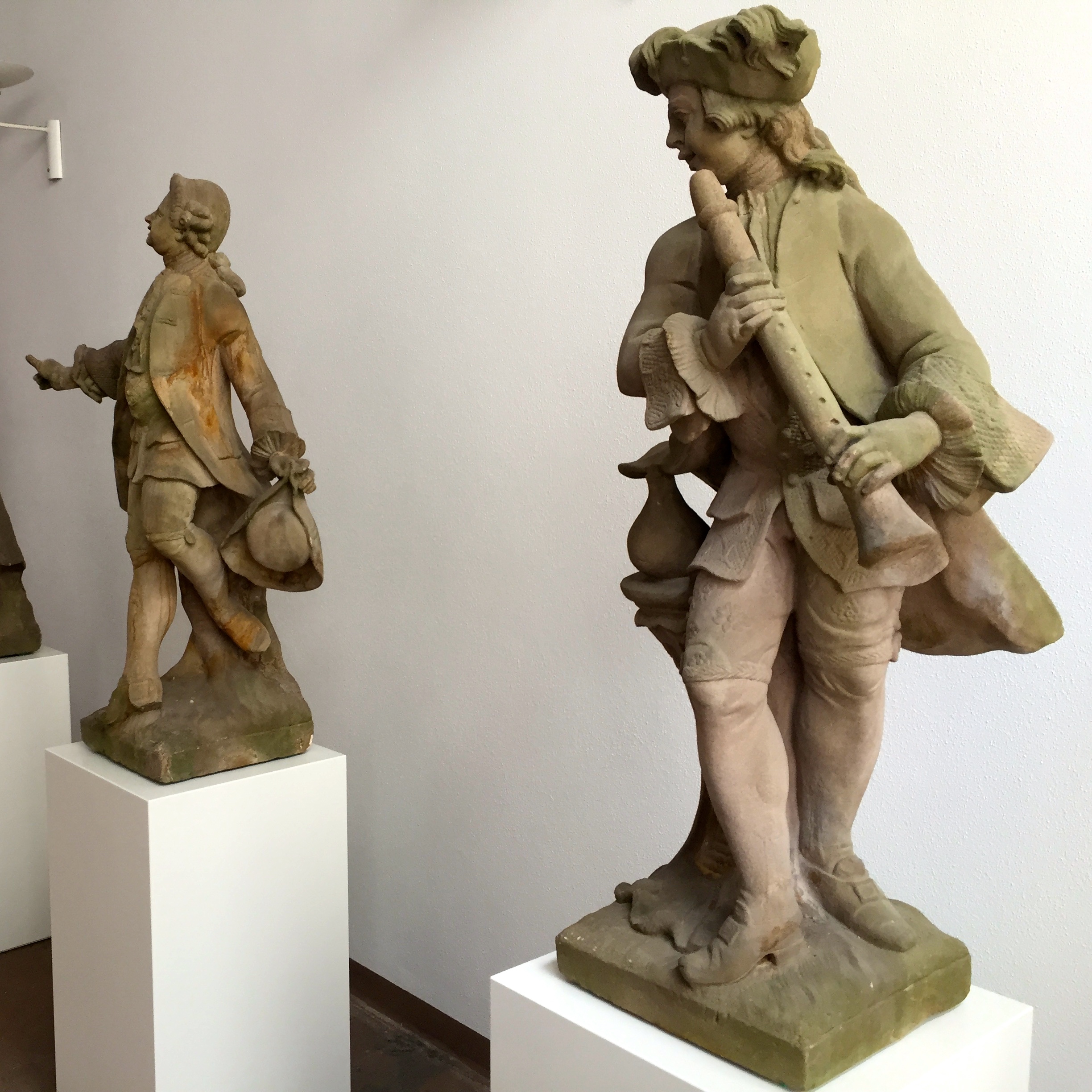 Die restaurierten Tietz Musikanten werden auf weißen Säulen präsentiert.