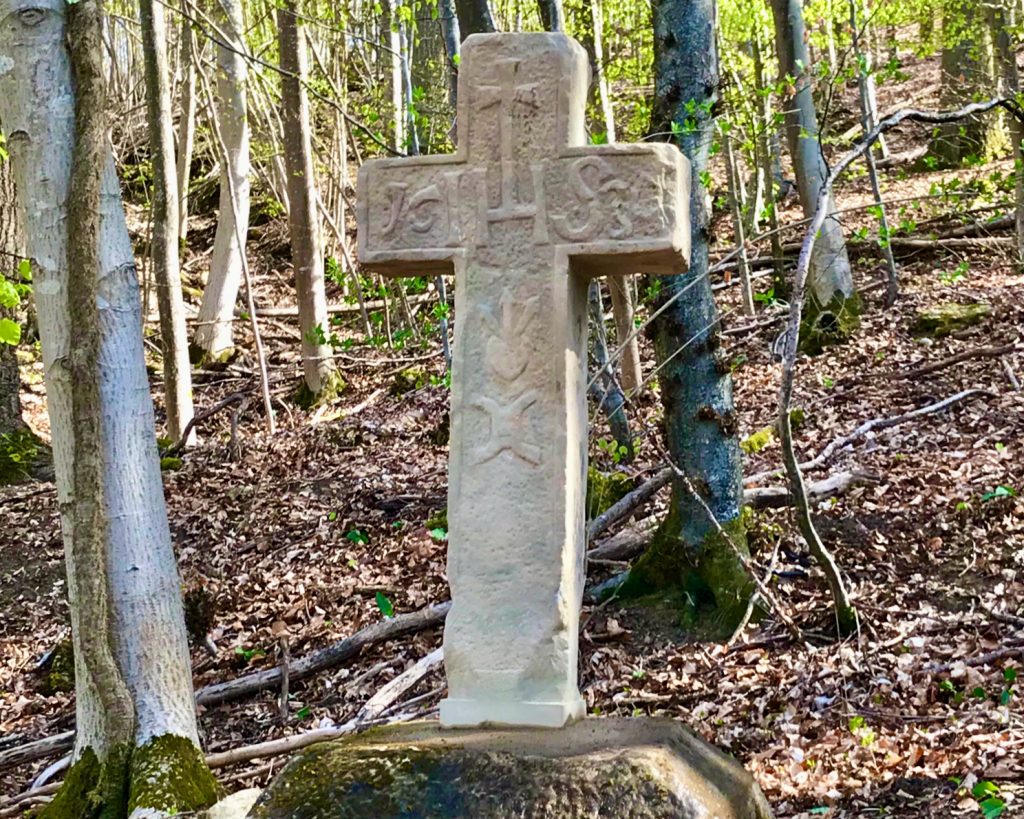 Ein Steinkreuz in einem Wald